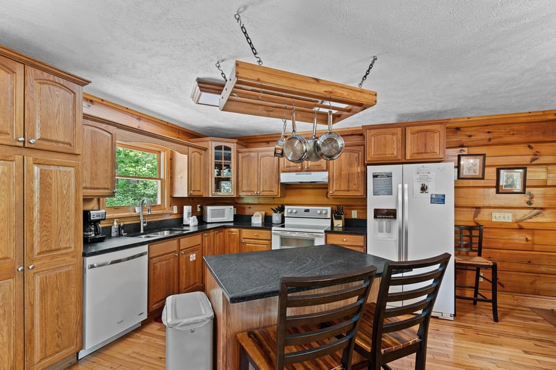 Breakfast bar for two in a kitchen with white appliances at Wildlife Retreat, a 3 bedroom cabin rental located in Pigeon Forge